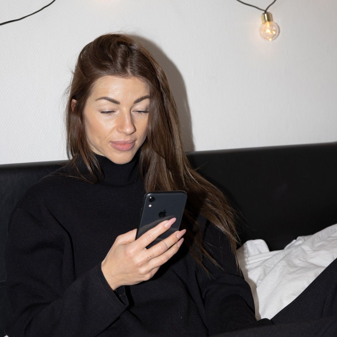 En kvinna som tittar ned i sin mobil.